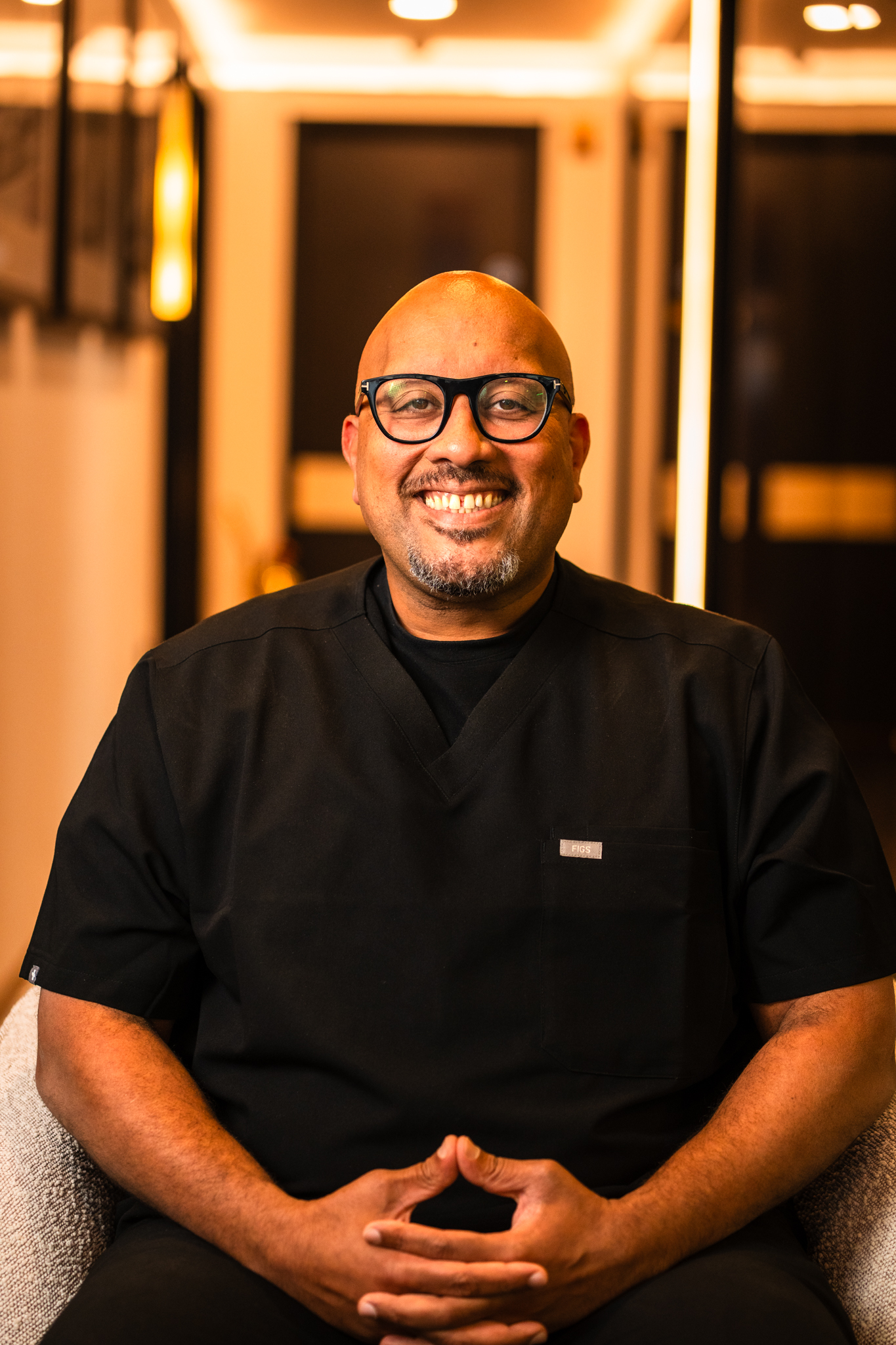 Kamran Rasul - The Dental Clinic - Dentist Dr Muhamad Gamal smiling in black scrubs